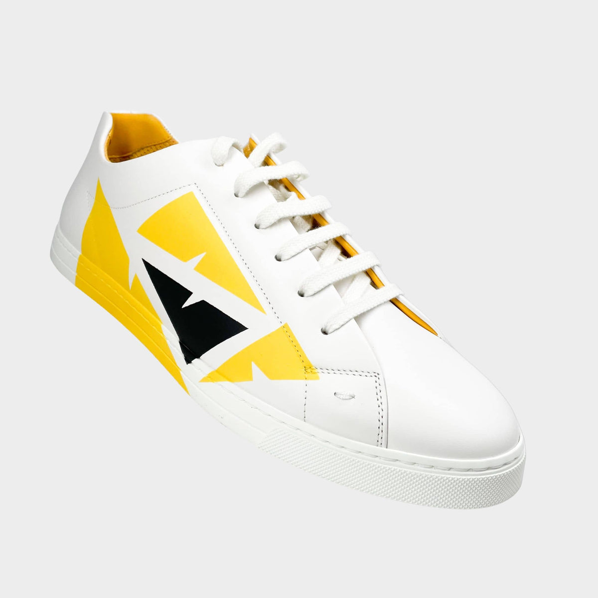 Fendi Men's Painted Bag Bugs sneaker in white leather with yellow hand-painted geometric motif.