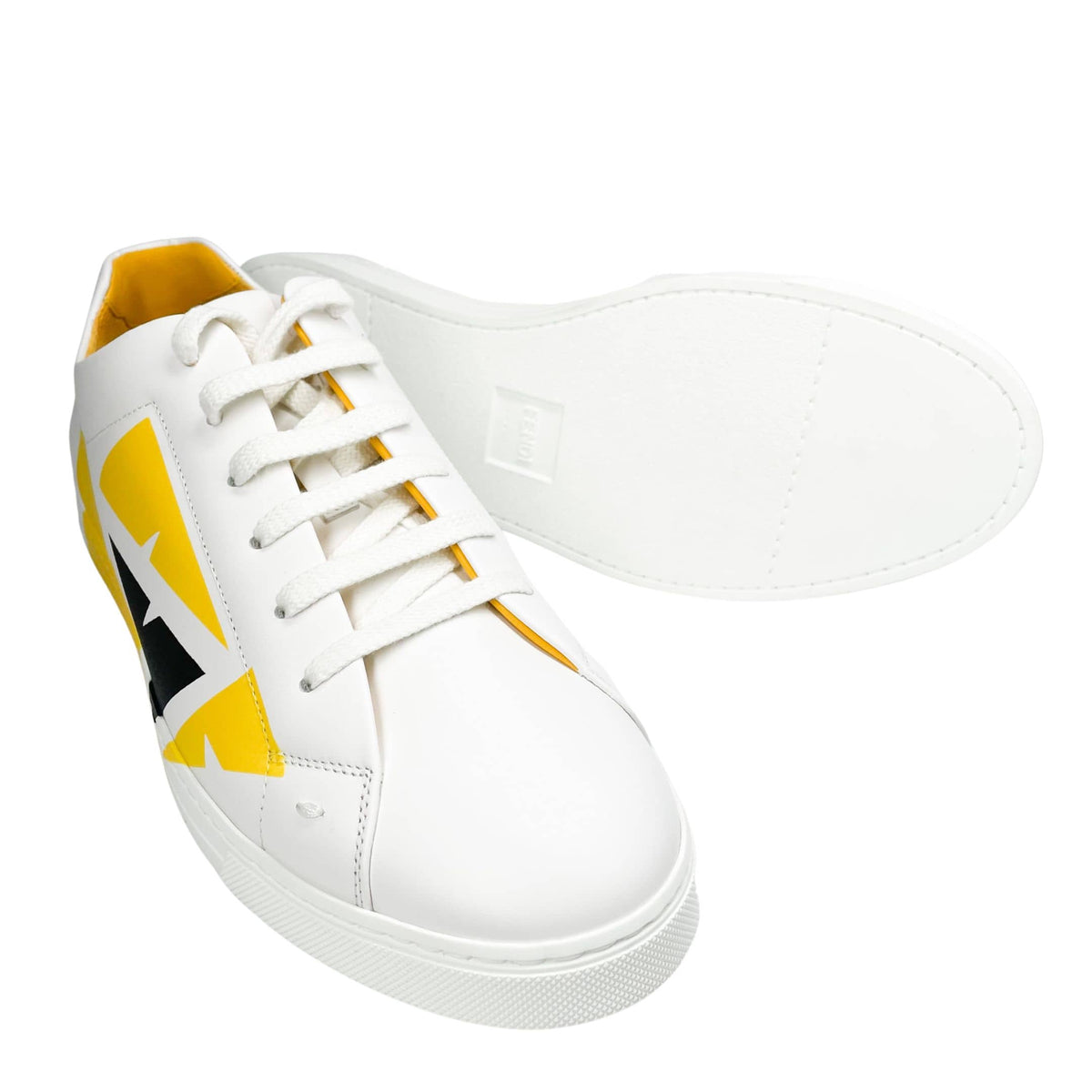 Angled side view of Fendi Painted Bag Bugs sneaker displaying treaded white outsole and leather upper.