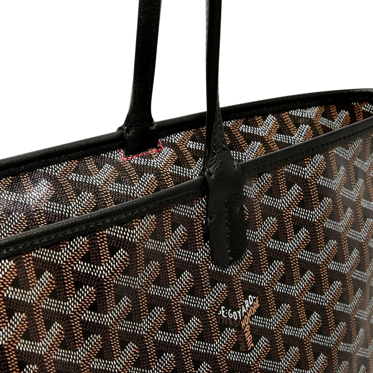Close-up view of Goyard Artois MM bag featuring hand-painted chevron pattern and black leather strap attachment.