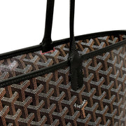 Close-up view of Goyard Artois MM bag featuring hand-painted chevron pattern and black leather strap attachment.