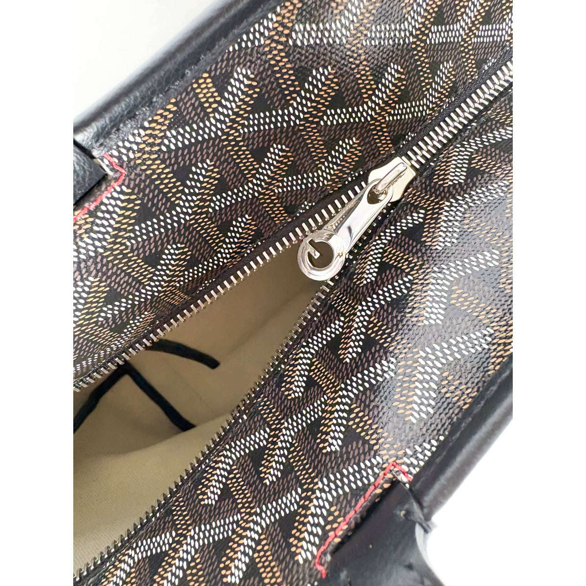 Detail view of Goyard Artois MM bag top zip-top closure with silver-tone hardware pull.