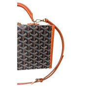 Three-quarter view of Goyard Grand Hôtel Trunk Bag detailing tan leather edge binding and strap attachment.