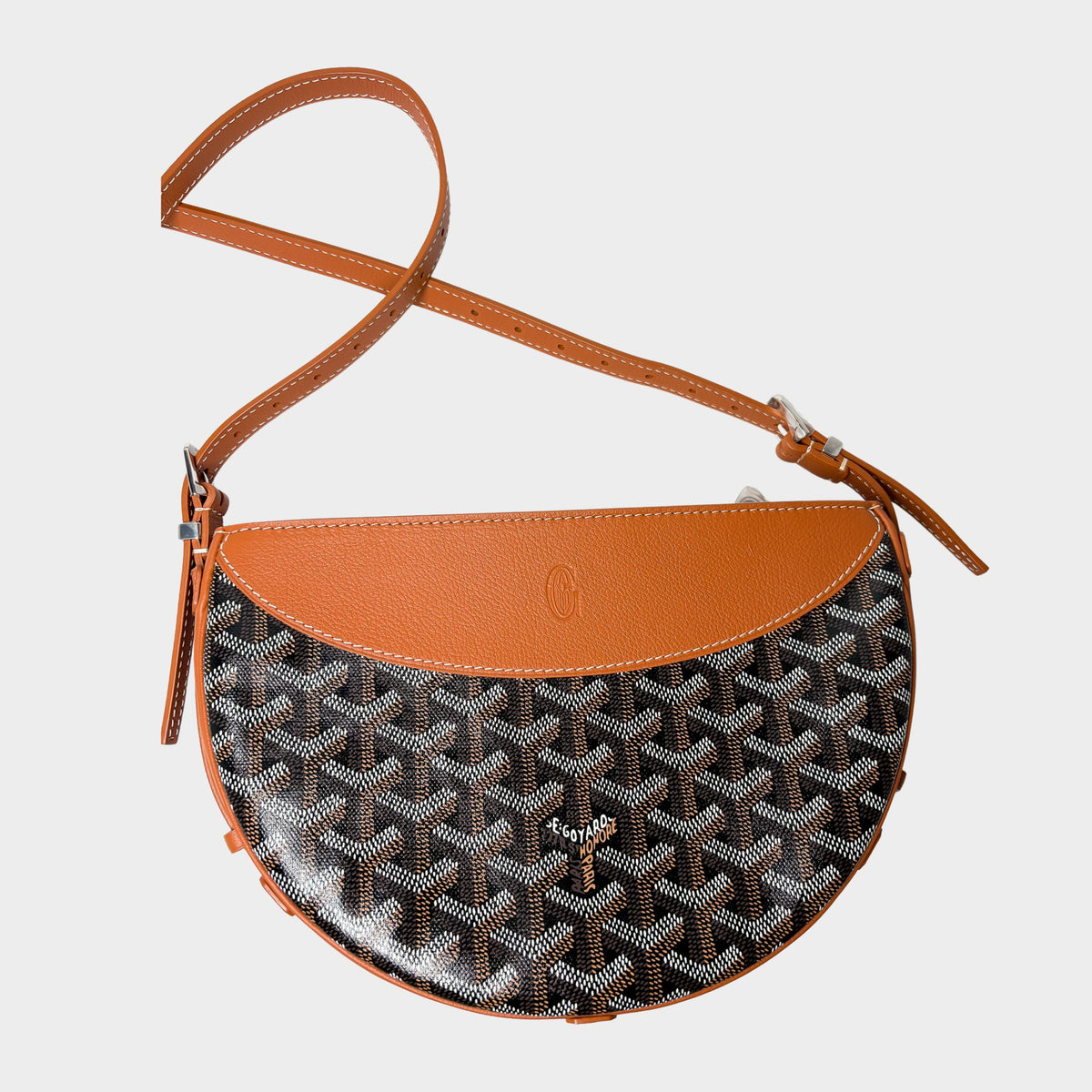 Goyard Hirondelle crossbody bag in black Goyardine canvas with tan leather curved trim and shoulder strap.