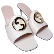 Top-down angled view of a pair of Gucci Blondie white leather high heel mules, revealing the tan leather insole lining and internal branding.