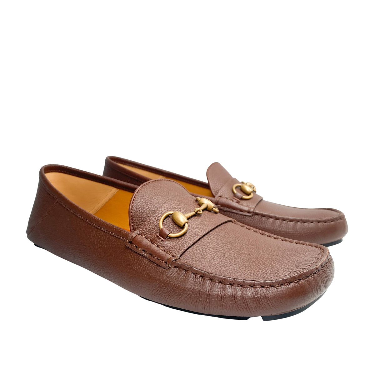 Angled side-by-side view of men's Gucci brown leather slip-on Horsebit shoes.