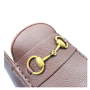Close-up view of Gucci brown loafer opening displaying tan leather lining and gold horsebit bar.