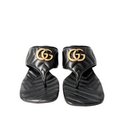 Symmetrical front-facing studio view of the black Gucci Charlotte thong sandals side-by-side, emphasizing the open square toe box.