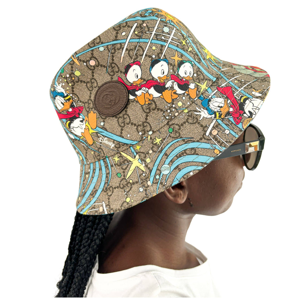 Angled view of Gucci x Disney Donald Duck GG monogram bucket hat showing crown shape and brown leather trim detail