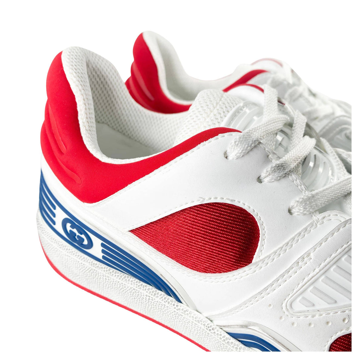 Close-up view of red synthetic side overlays and breathable mesh paneling on Gucci Flashtrek shoes.