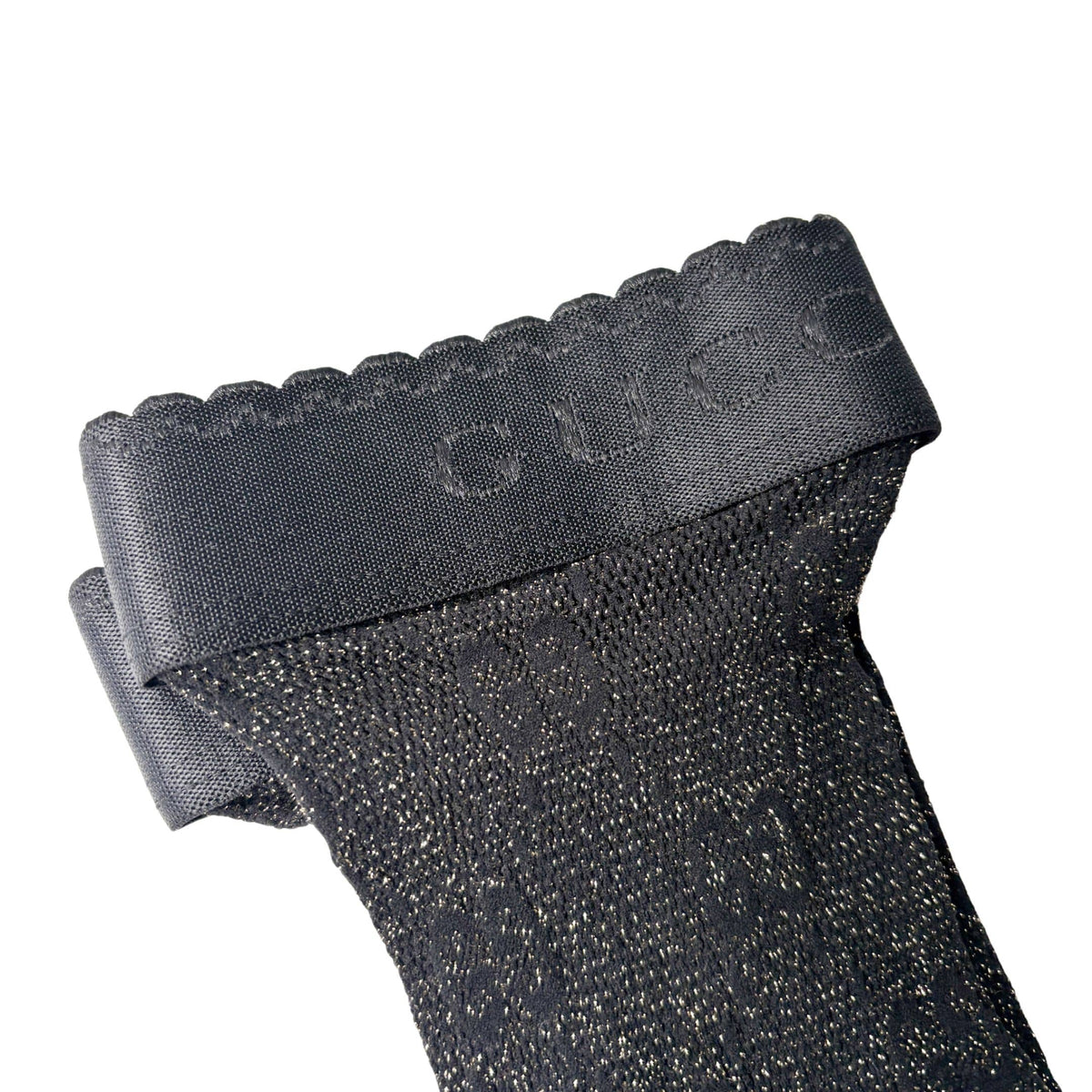 Detailed close-up of the black Gucci net stockings highlighting the ribbed cuff band and delicate GG monogram mesh knit.