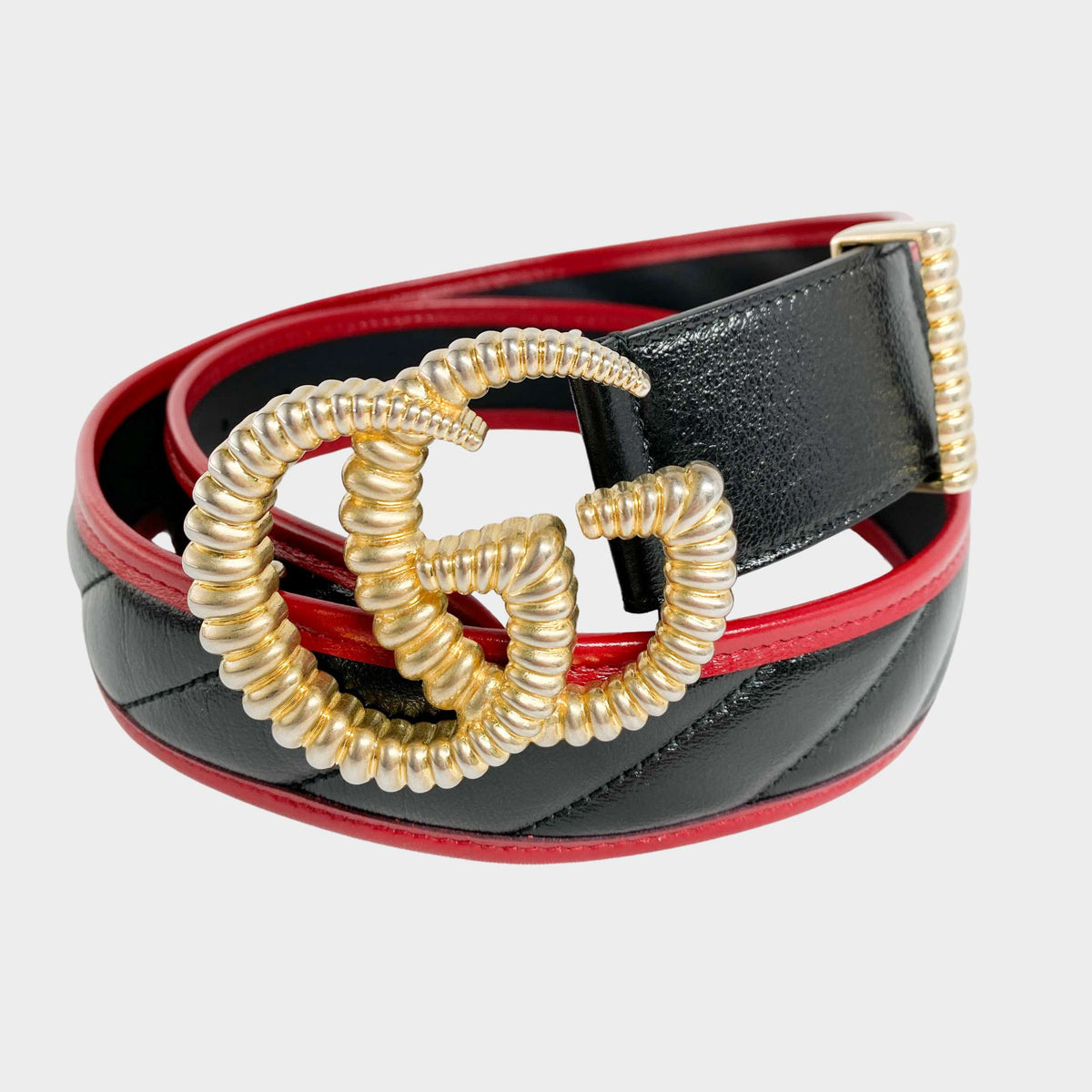 Front view of the Gucci GG Torched Buckle belt in black leather with red trim, featuring a torch-textured gold-tone double G logo.