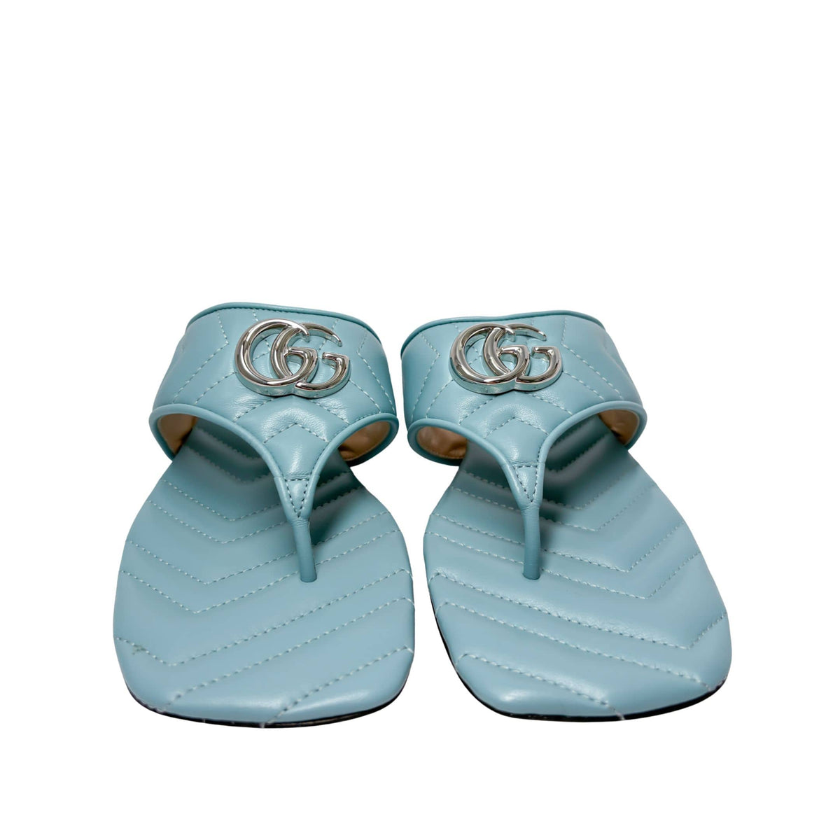 Symmetrical front view of a pair of Gucci Marmont Charlotte slide sandals side-by-side, showcasing the open toe design and silver double G hardware.