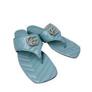 Three-quarter studio perspective of both Foggy Sky blue Gucci Charlotte sandals, highlighting the elegant slip-on silhouette and flat sole.