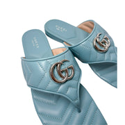 Detailed close-up shot of the Gucci Marmont Charlotte slide, emphasizing the fine stitching on the quilted leather and the polished silver metal logo.