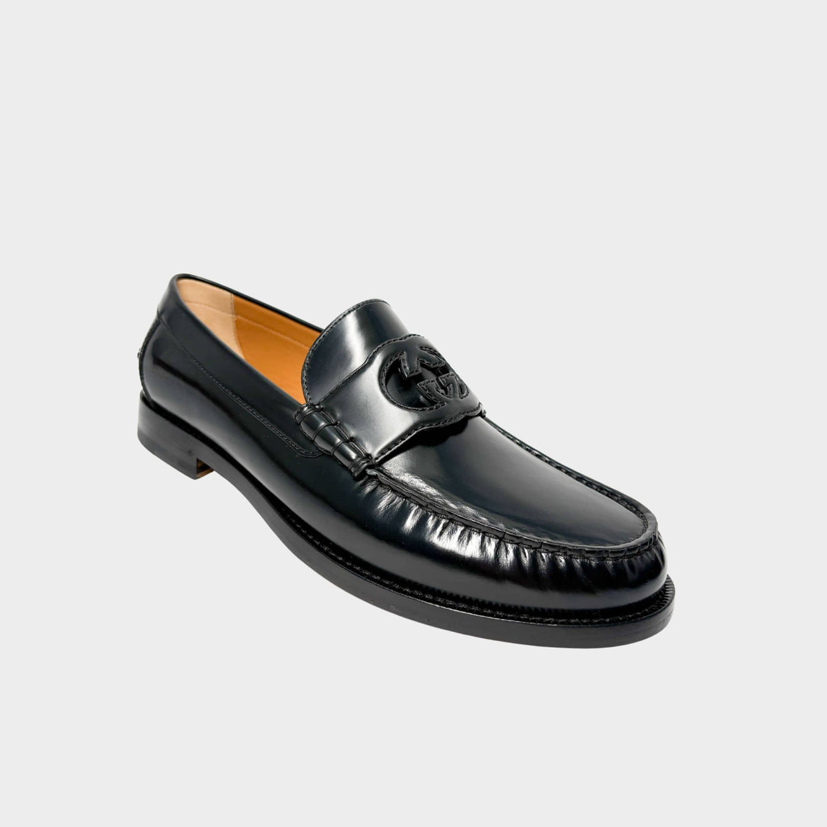 Gucci Millennial Ribot black leather loafer three-quarter profile view highlighting smooth leather construction and classic moccasin stitching.