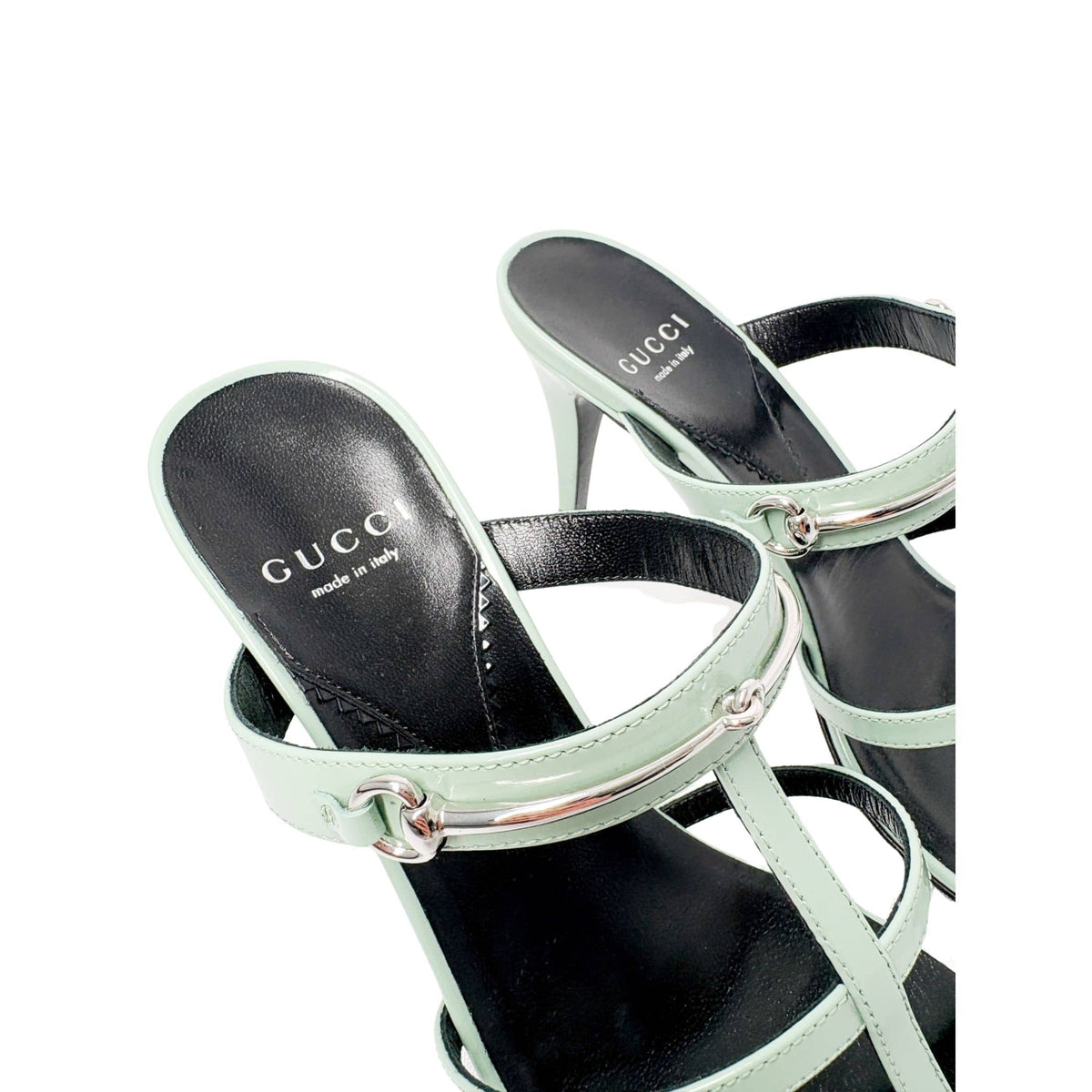 Three-quarter rear perspective of the green Gucci Regent sandals, highlighting the slender stiletto high heel and polished leather footbed.