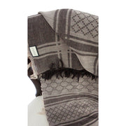 Vertical view of folded brown Gucci GG monogram wool scarf displaying classic pattern layout and frayed edges.