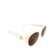 Gucci white GG sunglasses presented alongside luxury red velvet hard case and satin flannel pouch