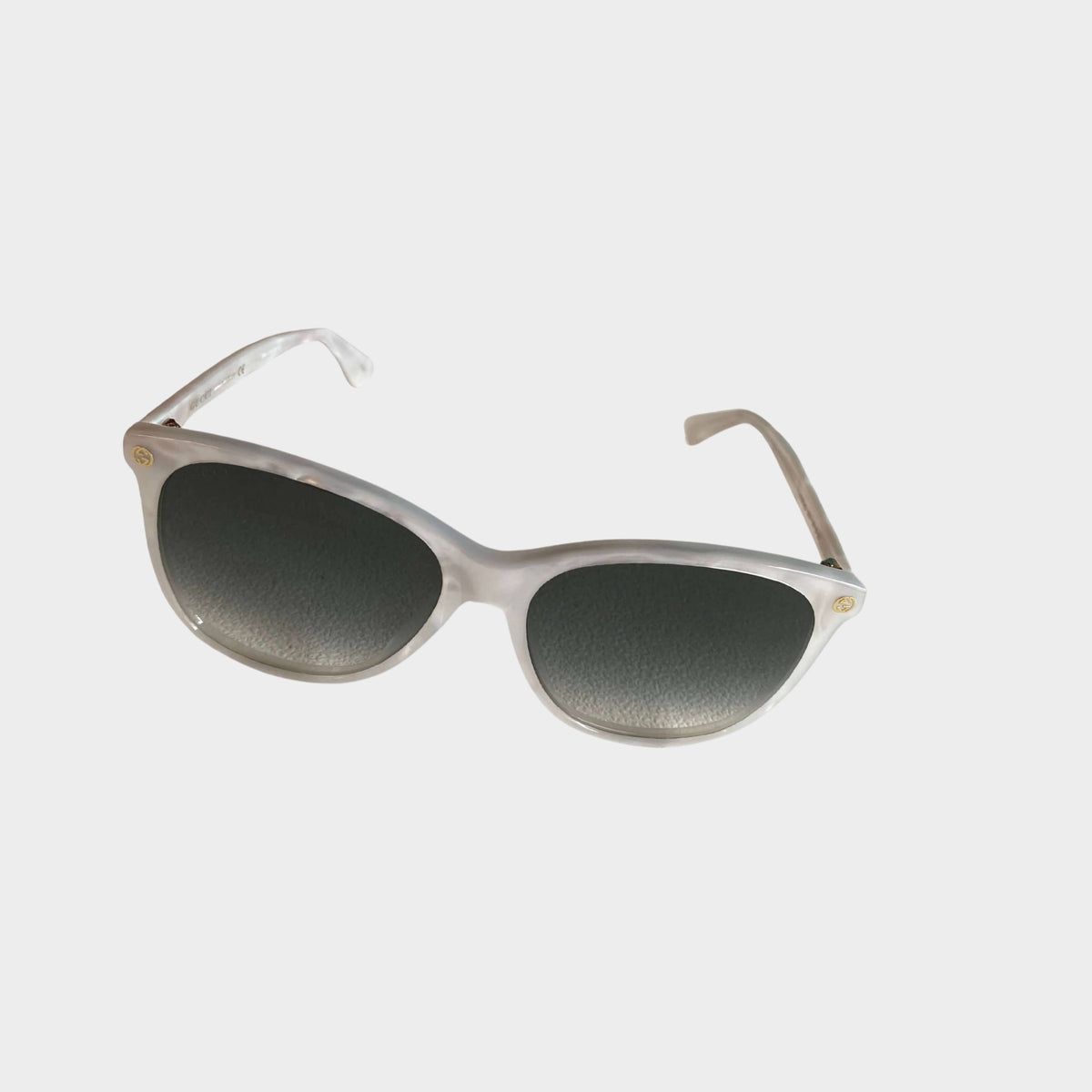 Front angled view of Gucci women's silver frame sunglasses with dark grey gradient lenses