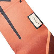 Close-up view of the Gucci silk scarf showcasing the woven brand label, hand-stitched borders, and smooth silk texture.