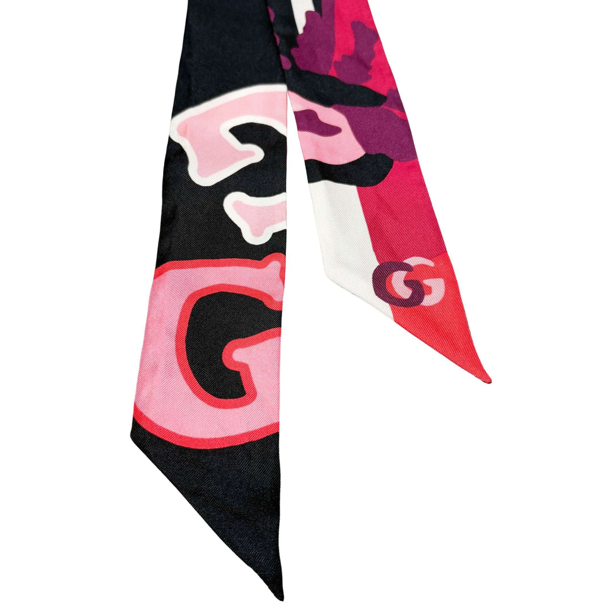 Detailed view of the Gucci silk twilly ribbon highlighting the bold interlocking GG pattern and floral motif accents.