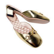 Detailed close-up shot of the gold leather Gucci mule, highlighting the fine stitching along the upper edge and the glitter of the crystal hardware.