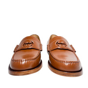 Front view of a pair of Gucci Millennial Ribot brown leather loafers displaying round toe box design and GG emblem detail.
