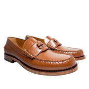 Three-quarter studio view of Gucci Millennial Ribot brown leather loafers highlighting the classic slip-on silhouette.