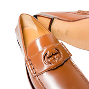 Close-up macro shot of Gucci Millennial Ribot brown loafer strap featuring embossed GG logo detail and smooth leather finish.