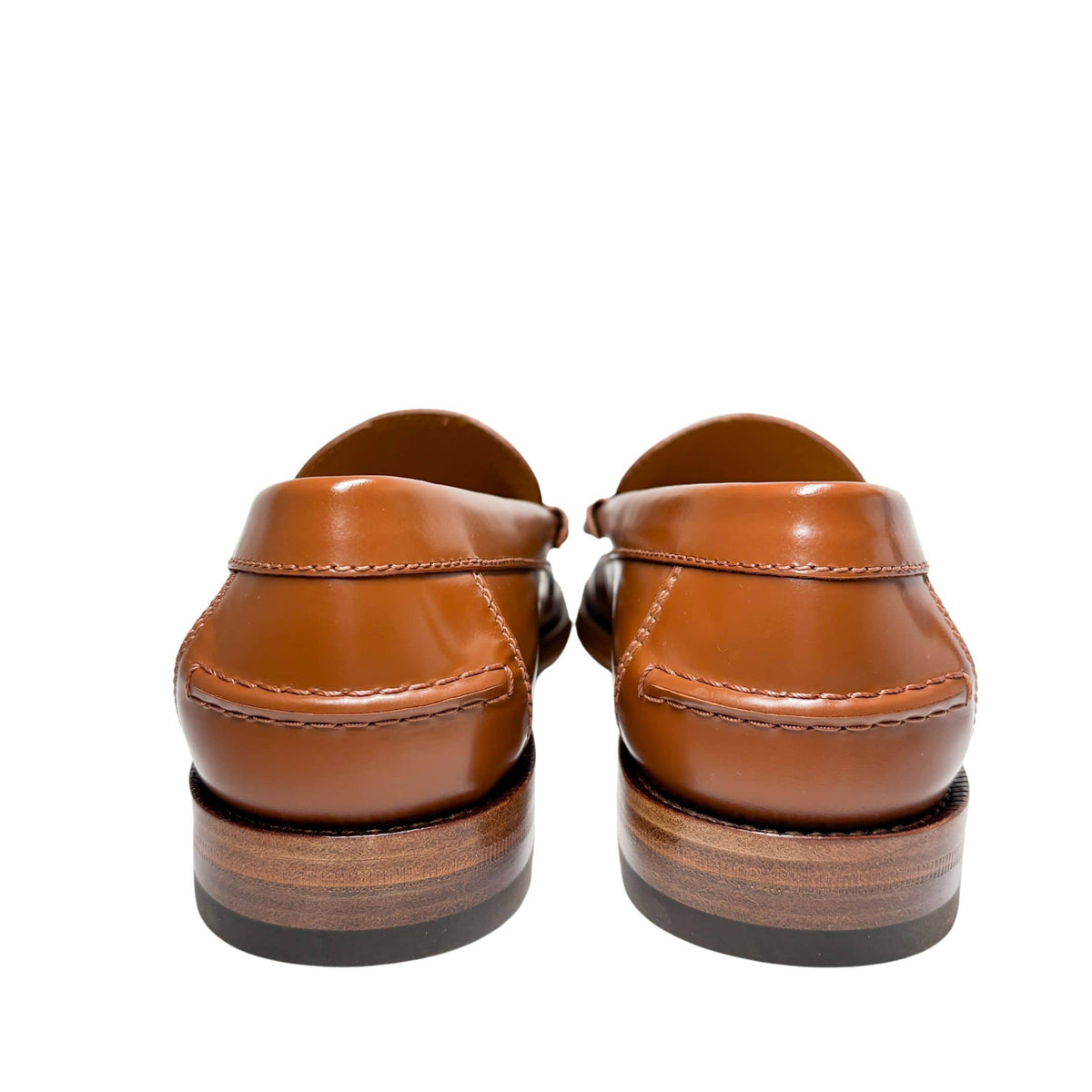 Rear view of a pair of Gucci Millennial Ribot brown leather loafers showing structured heel counters and stacked flat heel profile.