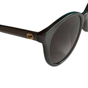 Close-up view of Gucci black sunglasses featuring the gold GG logo on the temple