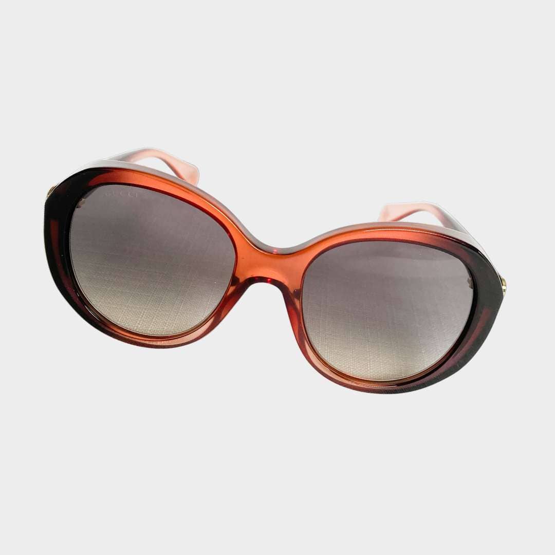 Front view of Gucci oversized round sunglasses with translucent pinkish-brown frames and gradient lenses.