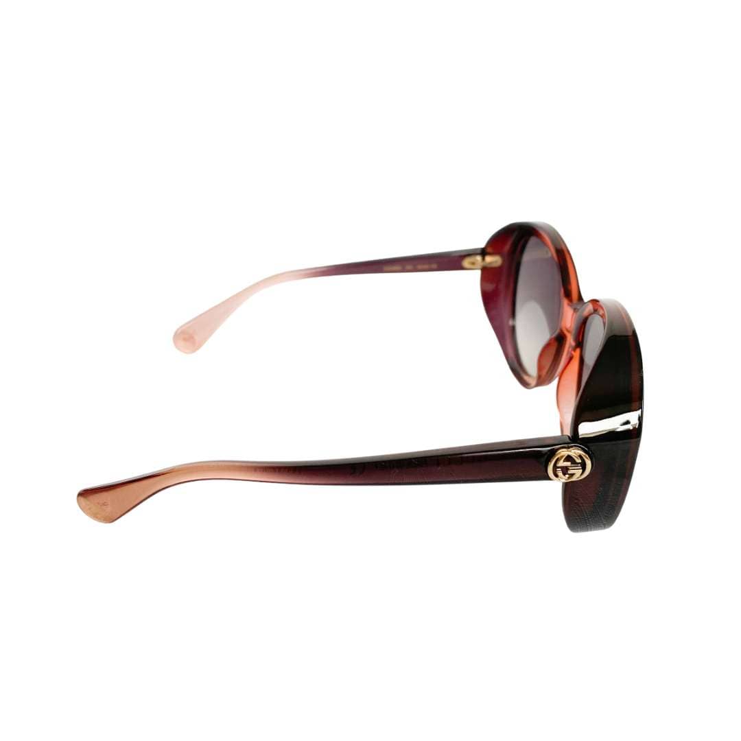 Side profile view of the pinkish-brown Gucci round sunglasses, highlighting the slim temple arm design.