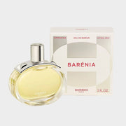 Hermès Barénia Eau de Parfum bottle with silver stud accents displayed next to its original white and rose gold retail box.