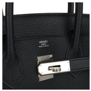 Close-up view of palladium hardware lock, keys, and hanging leather clochette on the Hermès Birkin 30 black handbag.