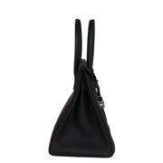 Side profile view of Hermès Birkin 30 in black Togo leather showing structured side gussets and rolled top handles.