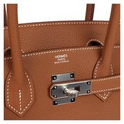 Close-up detail view of silver palladium hardware, padlock, and hanging leather key clochette on the Hermès Birkin 30 Gold bag.