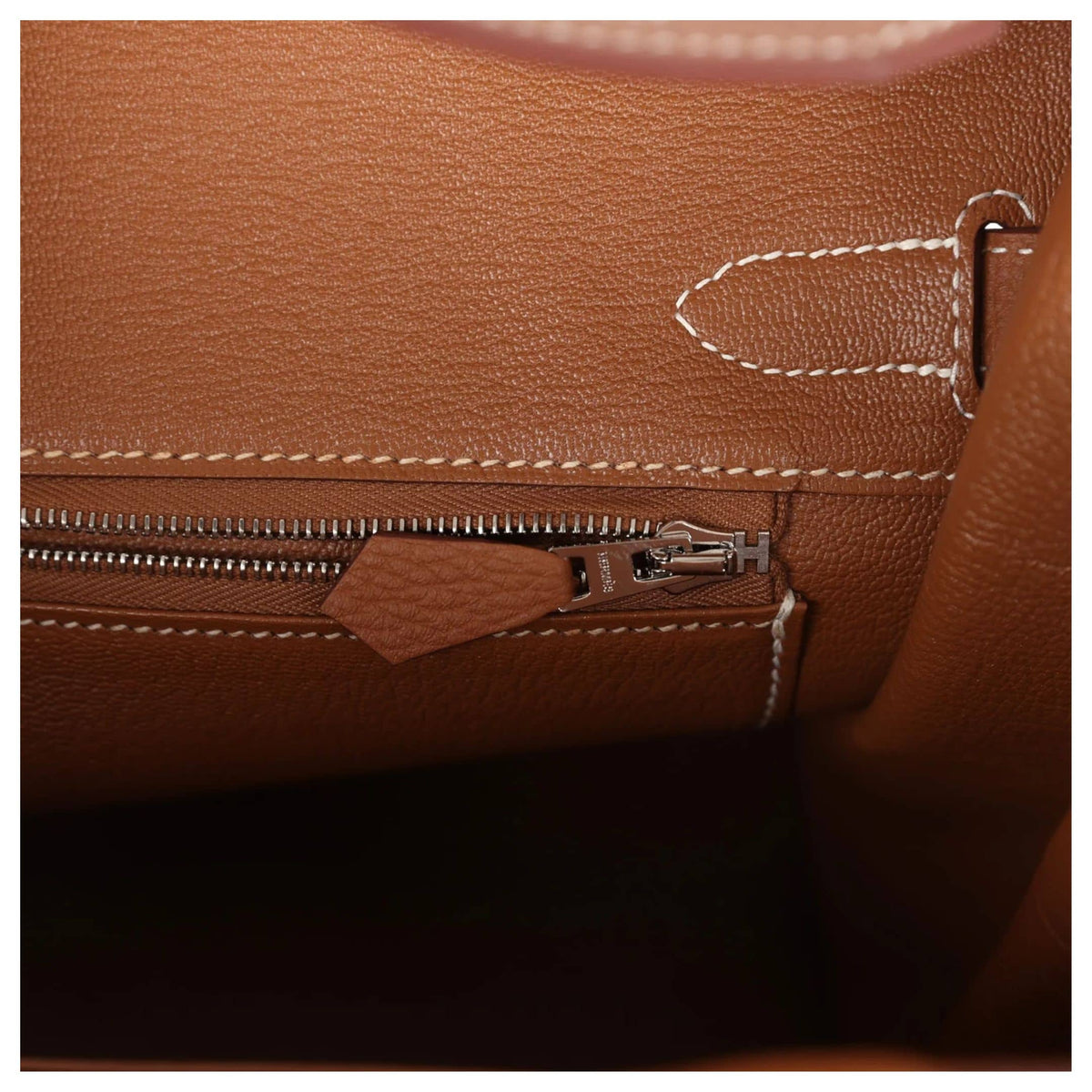 Macro view of interior heat stamp and zip pocket inside the Hermès Birkin 30 handbag in Gold Togo leather.