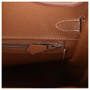 Macro view of interior heat stamp and zip pocket inside the Hermès Birkin 30 handbag in Gold Togo leather.