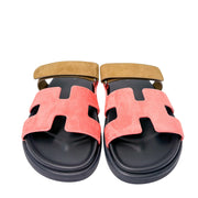 Symmetrical studio shot of both Hermès Chypre sandals side-by-side, highlighting the signature anatomical black calfskin footbeds and open toe design.