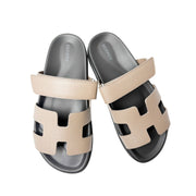 Overhead top-down view of a pair of Hermès Chypre sandals in Etoupe calfskin, displaying the tonal insoles and matching stitching details.