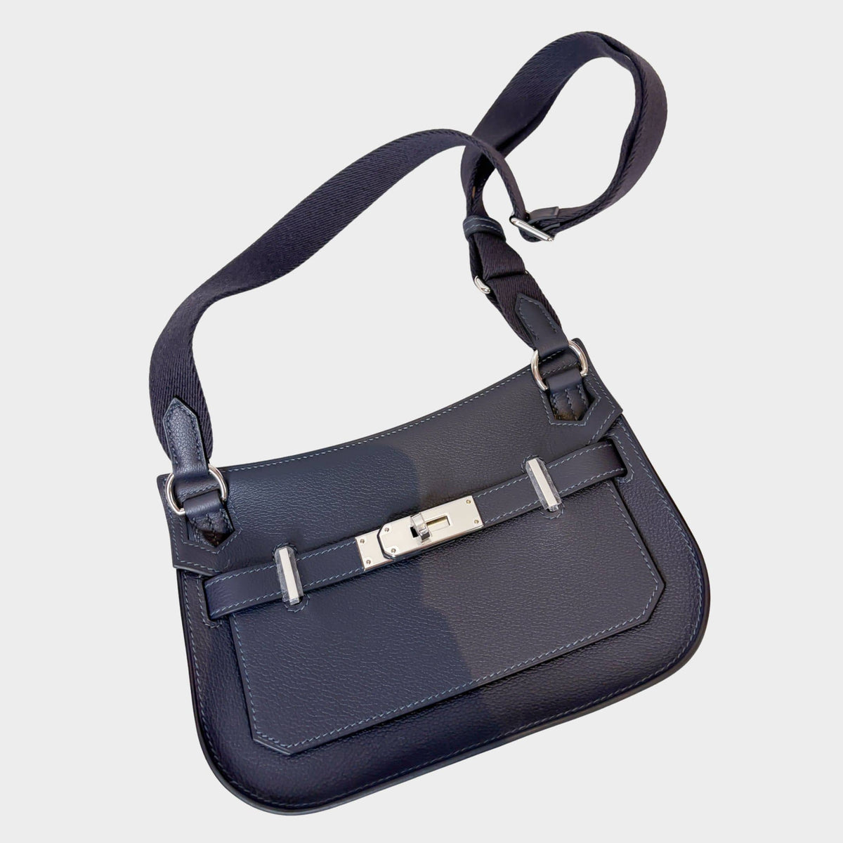 Hermès Jypsière messenger bag in dark blue leather featuring palladium hardware turn-lock closure and adjustable shoulder strap.