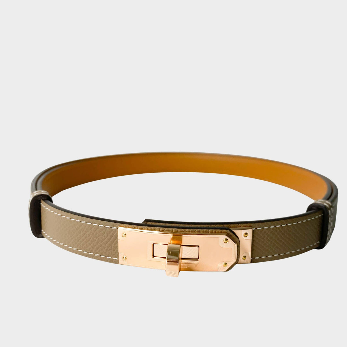 Hermès Kelly belt in Étoupe epsom leather featuring iconic rose gold Kelly turn-lock buckle
