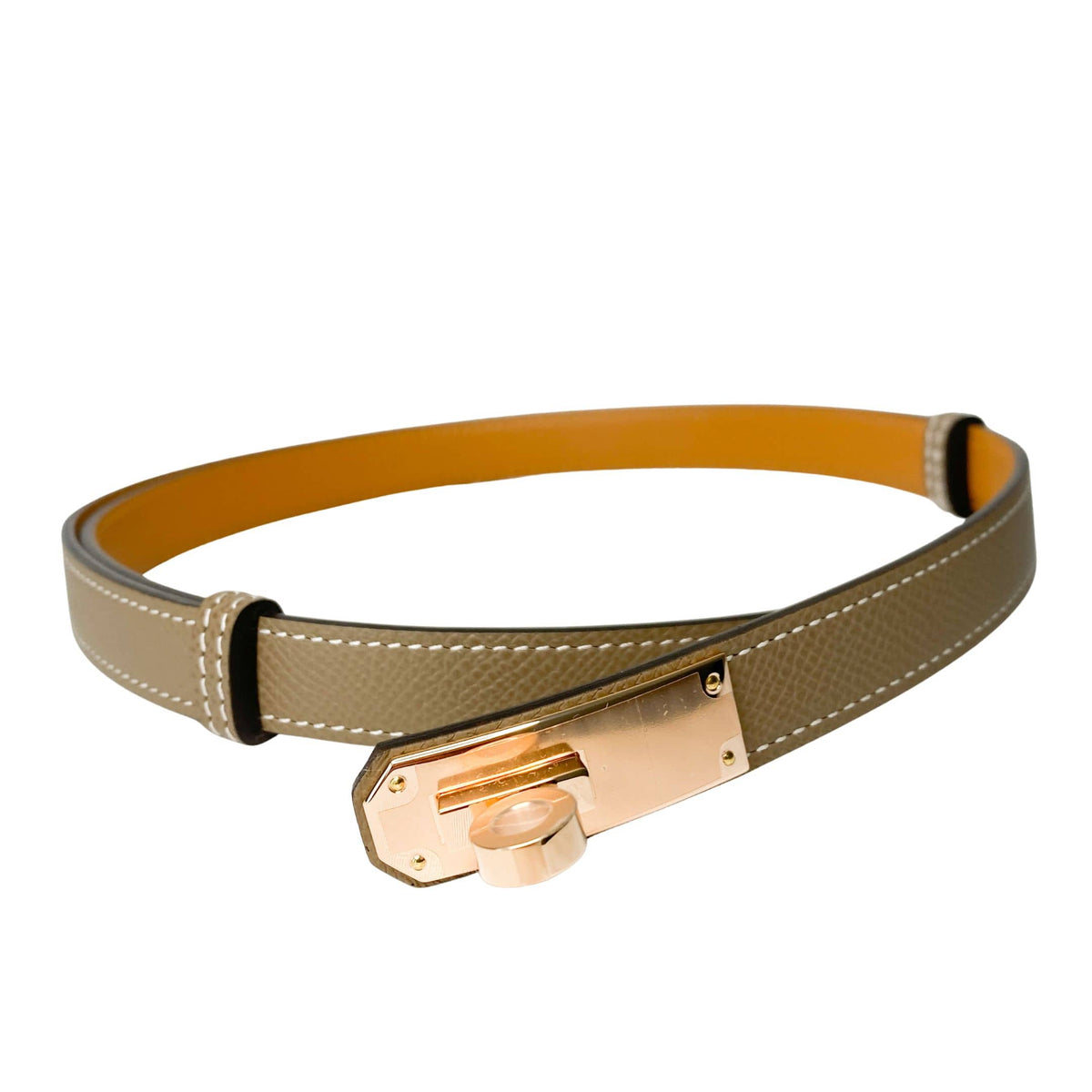 Angled view of Hermès Étoupe leather Kelly belt showing smooth finish and rose gold hardware closure