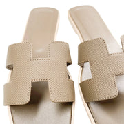 A unique overhead perspective looking straight down onto the open heel entry of the Oran sandals, drawing focus to the smooth texture of the neutral taupe leather lining.