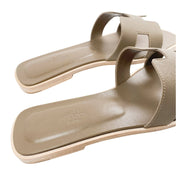 A close look at the sandal resting at a three-quarter angle, illustrating the low-profile height and minimal structure characteristic of timeless resort footwear.