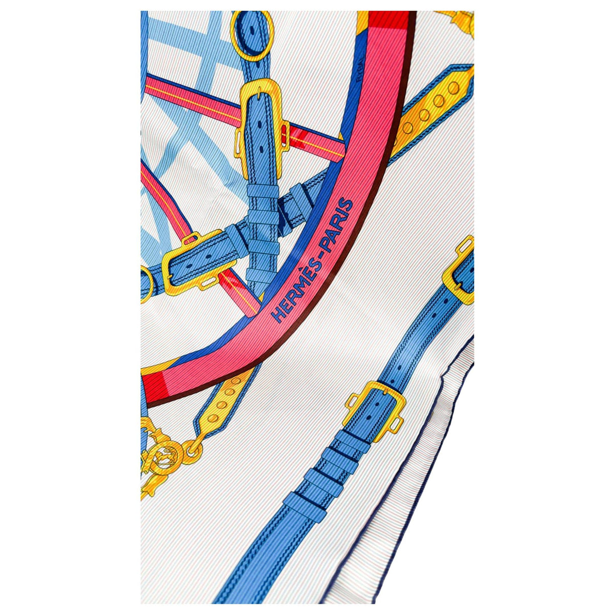 Close-up view of Hermès En Roue Libre silk scarf showing intricate intersecting blue, pink, and yellow harness linework details
