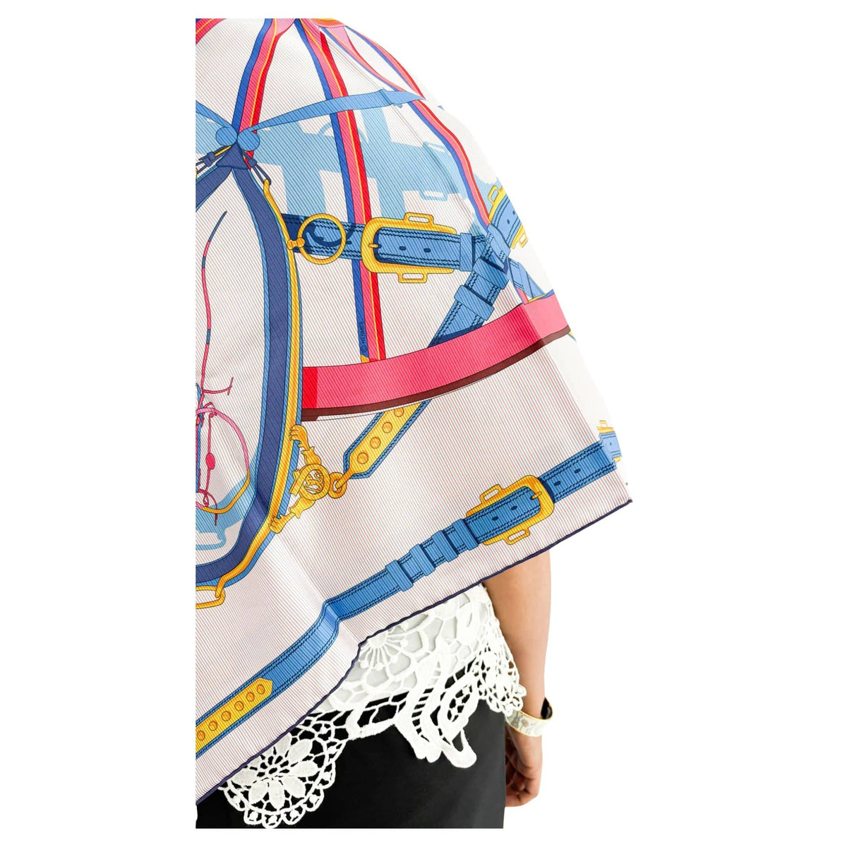 Side view of model wearing Hermès En Roue Libre multicolored silk scarf styled over a black outfit