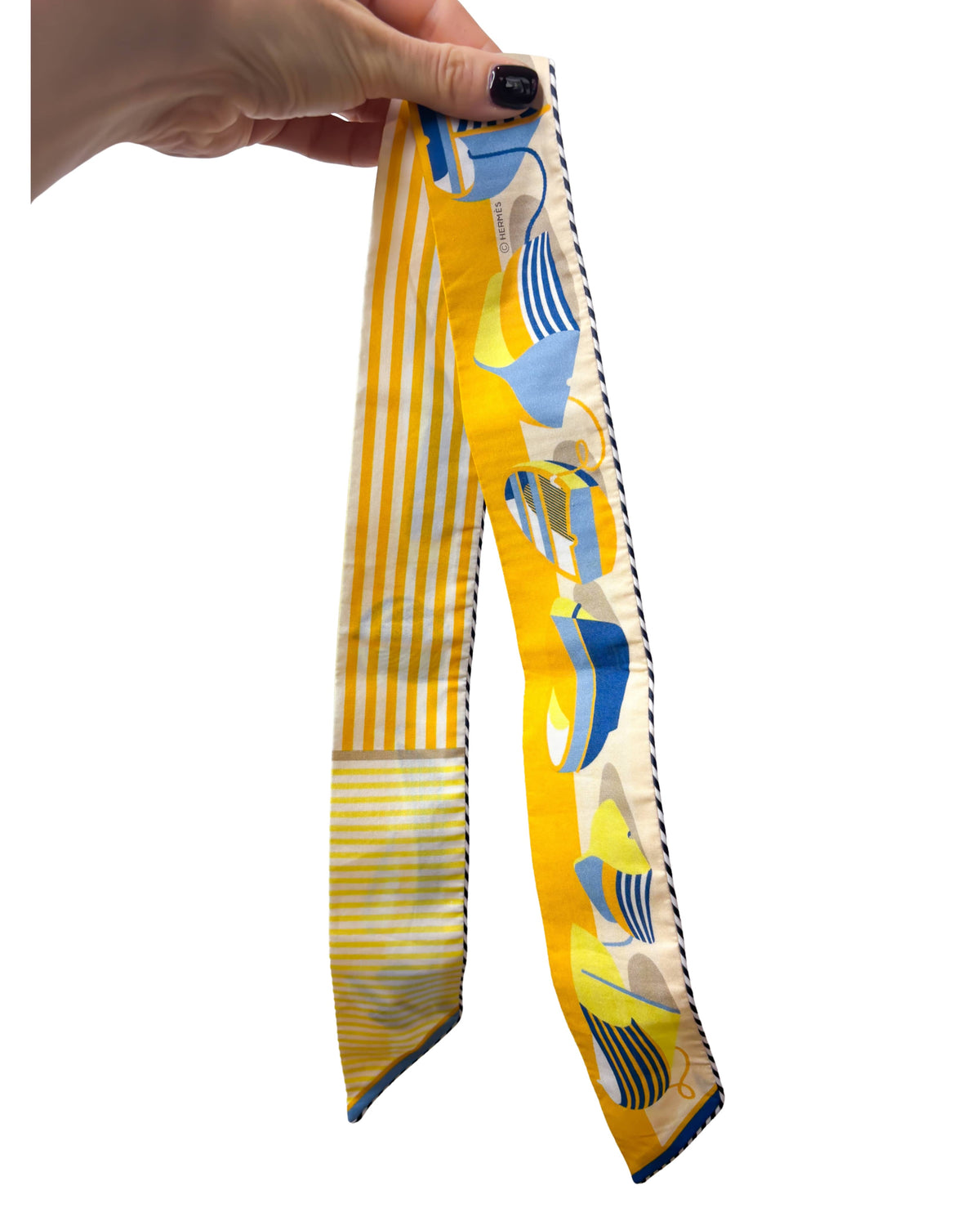 Side angle presentation of Hermès Thalassa yellow cotton Twilly scarf wrapped around a decorative display pedestal