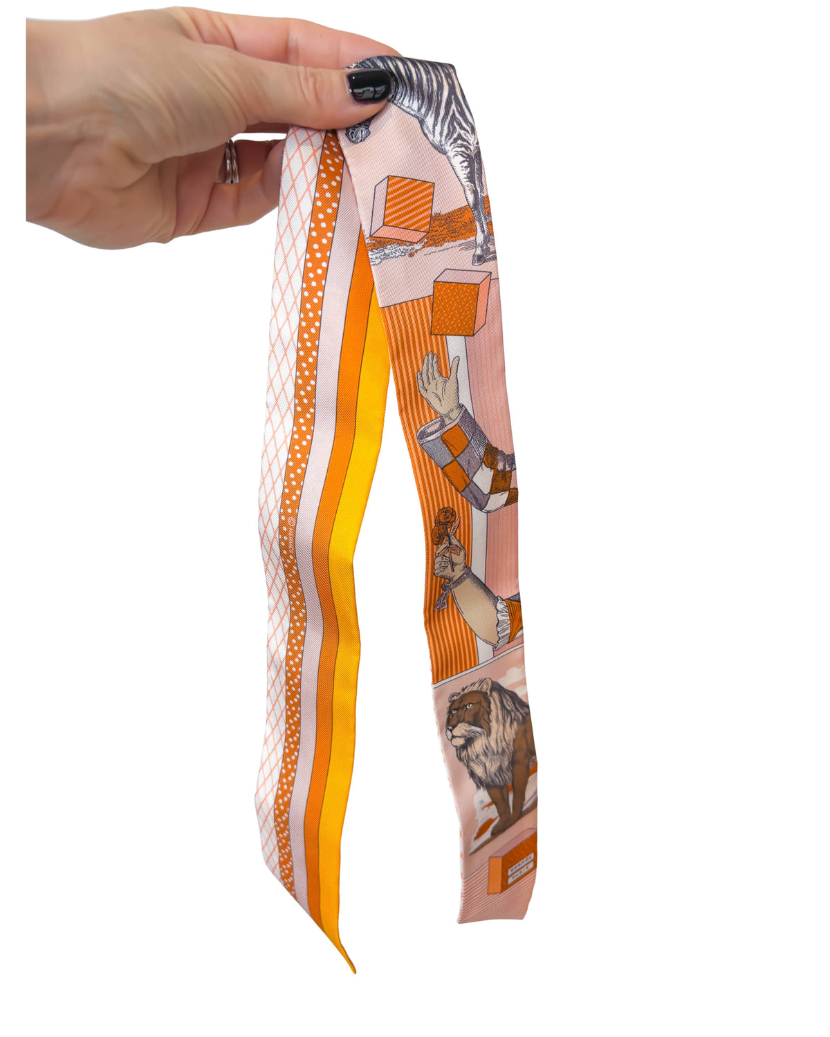 Close-up view of Hermès Grand Théâtre Nouveau silk Twilly scarf in orange and poudre pink showing the illustrated theatrical print